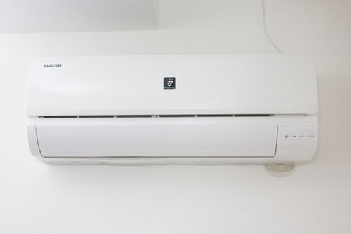 壁の穴を隠して取り付けたエアコン室内機