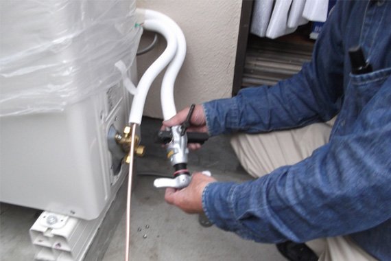 室外機に作業をする人